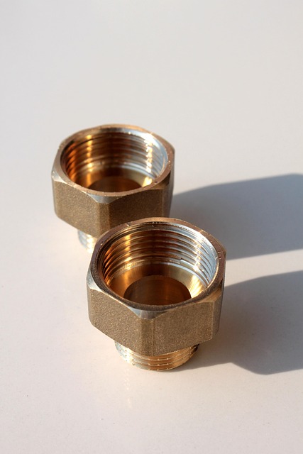 Wide angle view of a large construction pipe warehouse with rows of PVC HDPE copper and steel pipes organised by type and size under industrial lighting